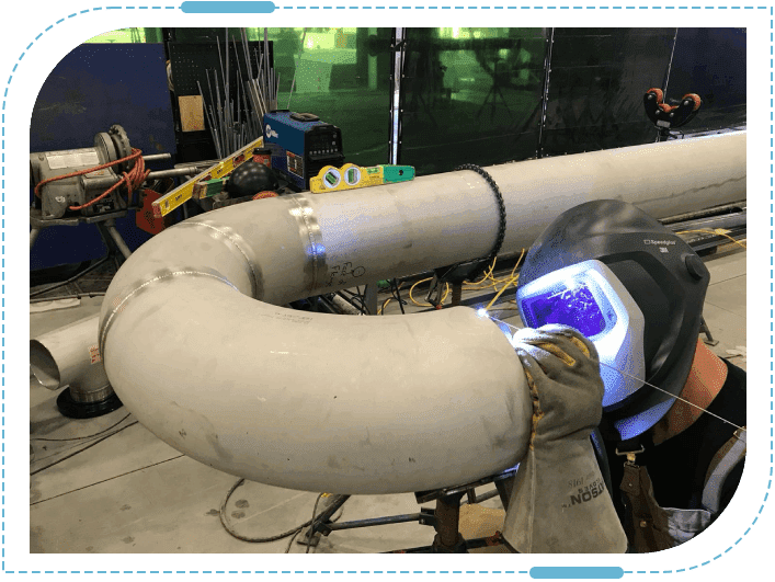 Welder working on large metal pipe