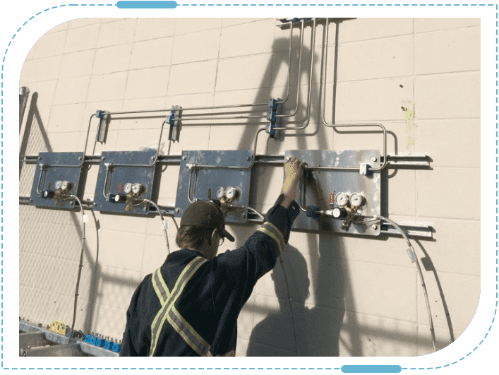 Worker installing gas meters on building wall