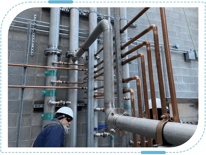 Industrial pipes with worker in helmet
